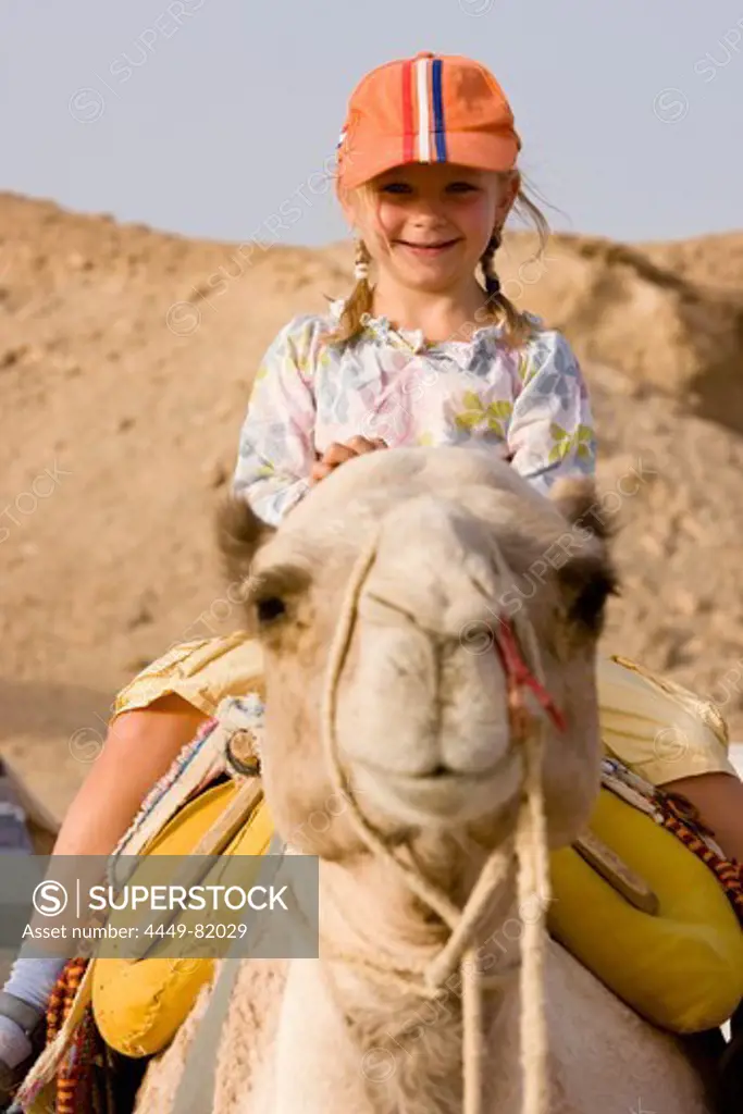 Child, girl, 5, riding a camel in the Marsa Alam desert, Red Sea, Egypt