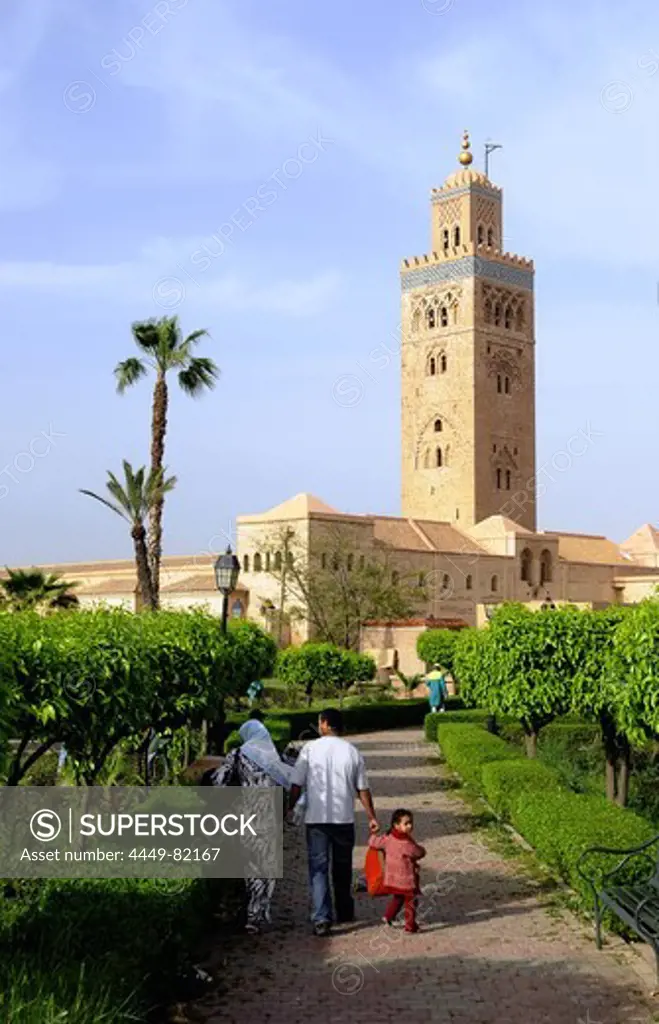 Family at a park in front of the Minaret of the Koutoubia Mosque, Marrakesh, South Morocco, Morocco, Africa