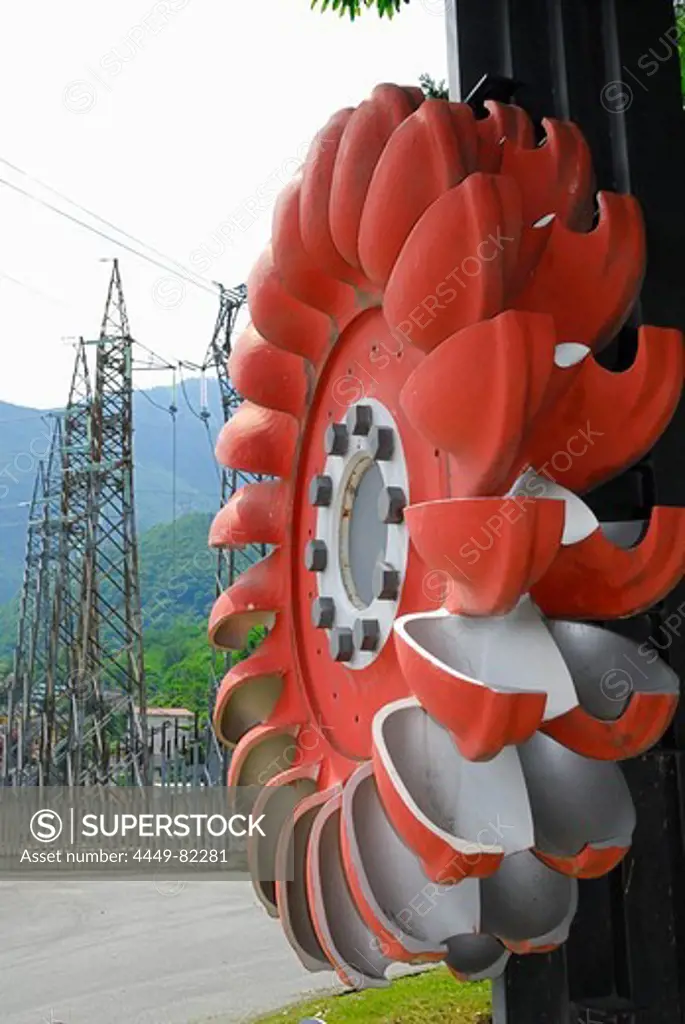 Turbine wheel with electricity pylons in the background, Pelton turbine, water power plant near Chiavenna, Ciavenna, Lombardy, Italy