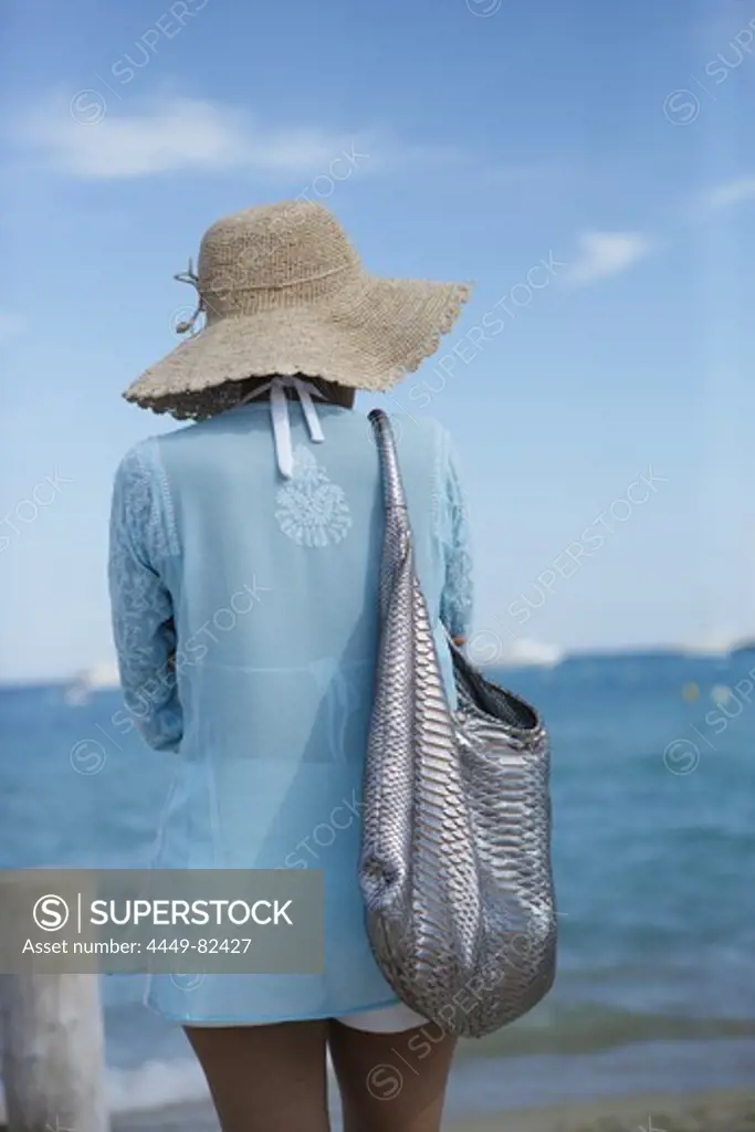 Young woman wearing a hat on the beach, Ramatuelle, Saint Tropez, Cote d´Azur, South of France, France, Europe