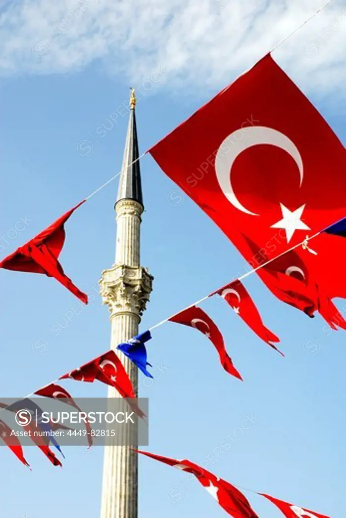 Ensigns in front of the minaret of the Dolmabahce Camii Mosque, Istanbul, Turkey, Europe