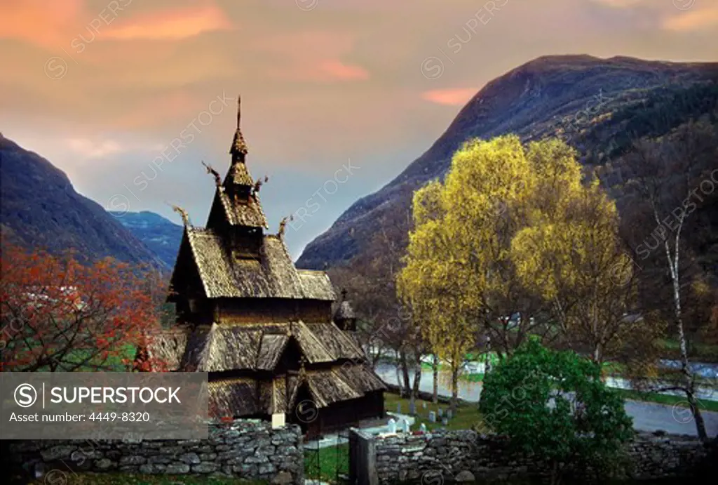 Stavechurch between trees and mountains in the evening, Borgund, Norway, Scandinavia, Europe