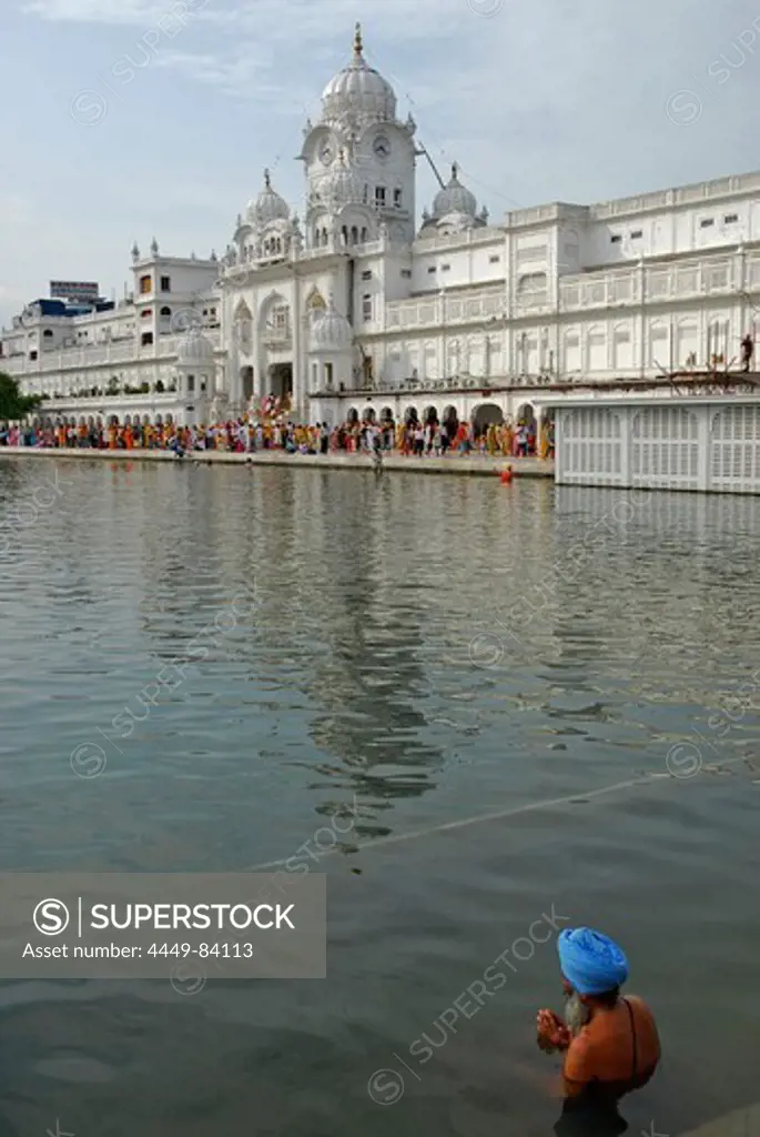 Man with turban bathing in water basin in front of the Golden Temple, view at main entrance, Sikh holy place, Amritsar, Punjab, India, Asia