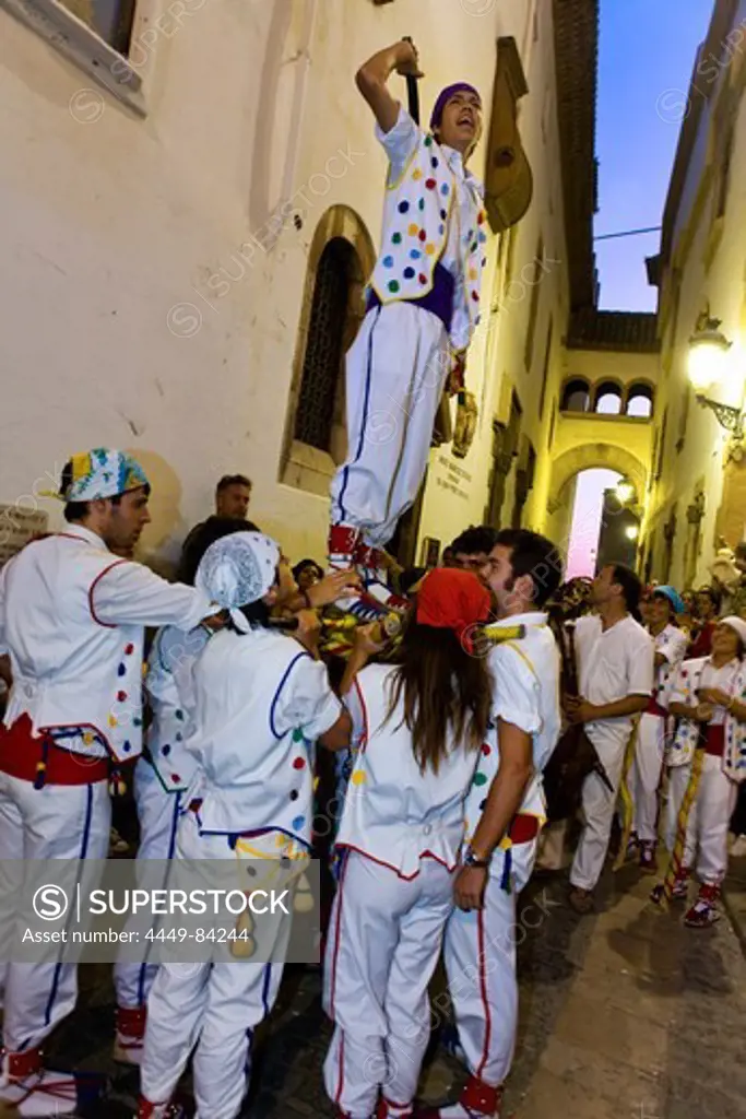 People in costumes in an alley in the evening, Festival of Santa Tecla, Sitges, Catalonia, Spain, Europe