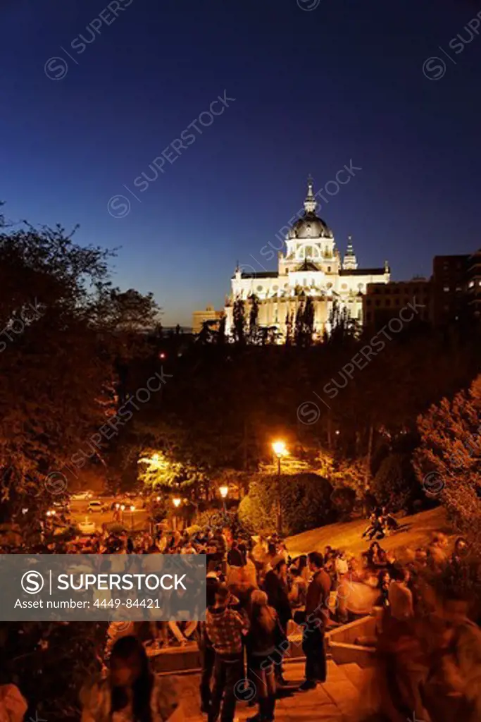 Catedral de Nuestra Senora de la Almudena at night, guests in a bar in foreground, Madrid, Spain