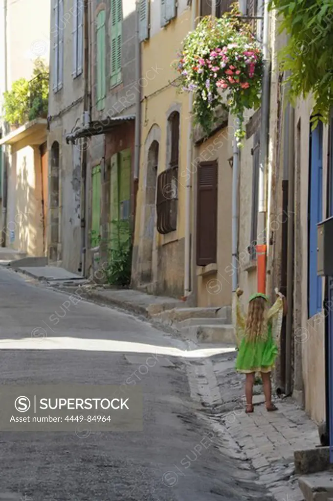 Girl wearing a green dress in the street in Valensole, Provence, France, Europe