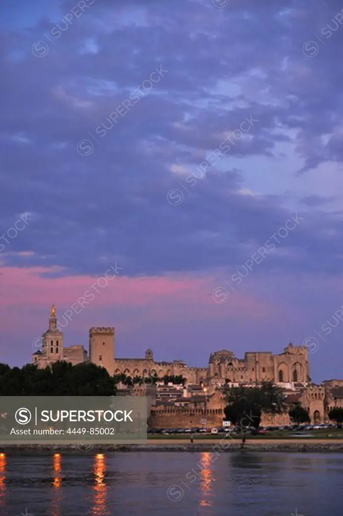 View over river Rhone to city walls, cathedral Notre-Dame-des-Doms and papal palace in the afterglow, Avignon, Vaucluse, Provence, France, Europe