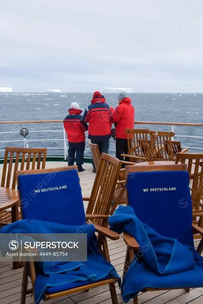 People on deck of cruiseship MS Deutschland (Deilmann Cruises) looking at antarctic icebergs, South Shetland Islands, Antarctica
