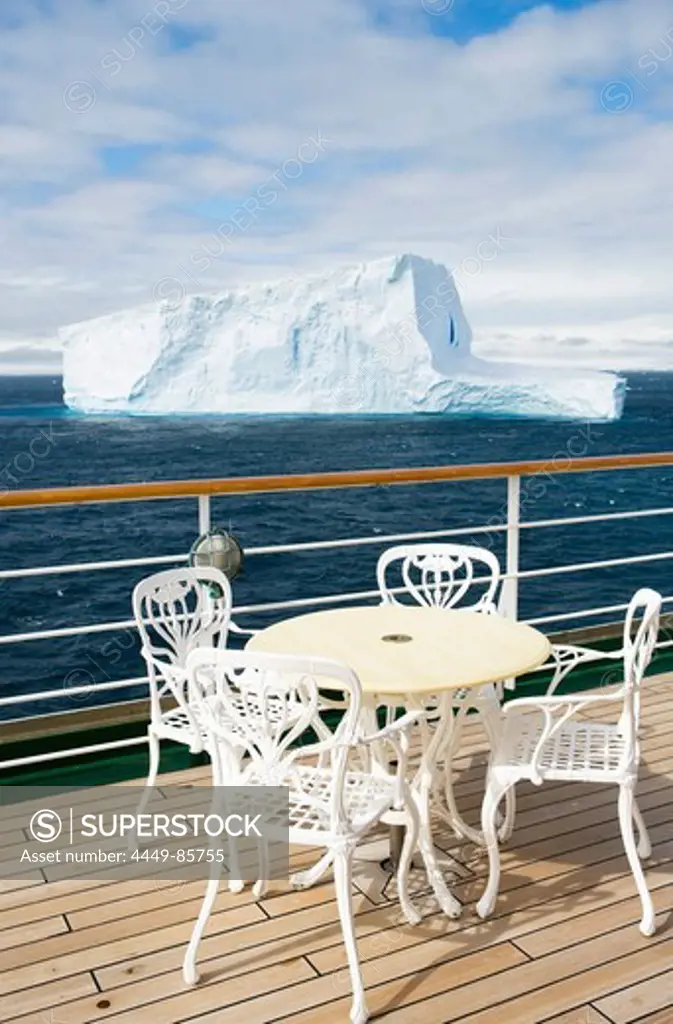 Table on deck of cruiseship MS Deutschland (Deilmann Cruises) and view at Antarctic iceberg, South Shetland Islands, Antarctica