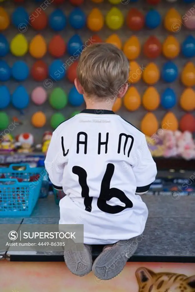 Young boy wearing a Phillip Lahm German National soccer team jersey at a dart booth at a funfair, Rotenburg an der Fulda, Hesse, Germany, Europe