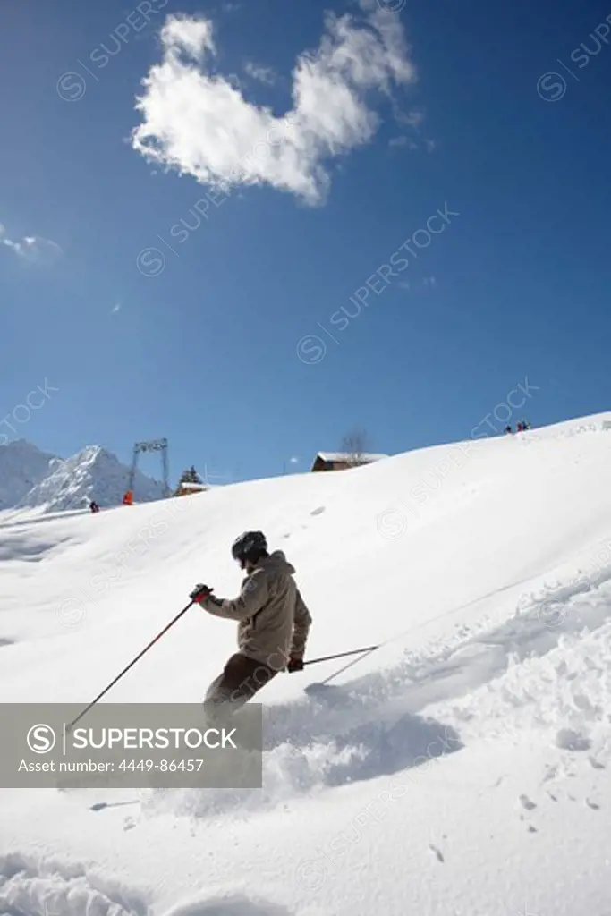 Man skiing in deep snow, Schlosslelift, Hirschegg, Kleinwalsertal, Vorarlberg, Austria