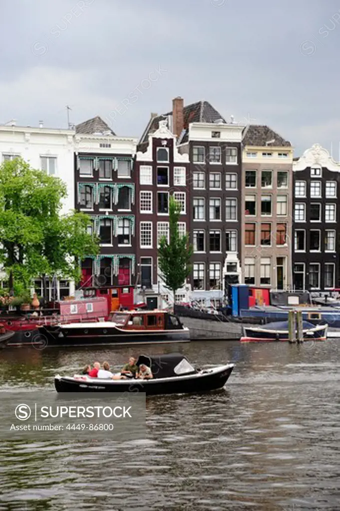 Boat, residential houses along the Amstel river, Amsterdam, the Netherlands, Europe