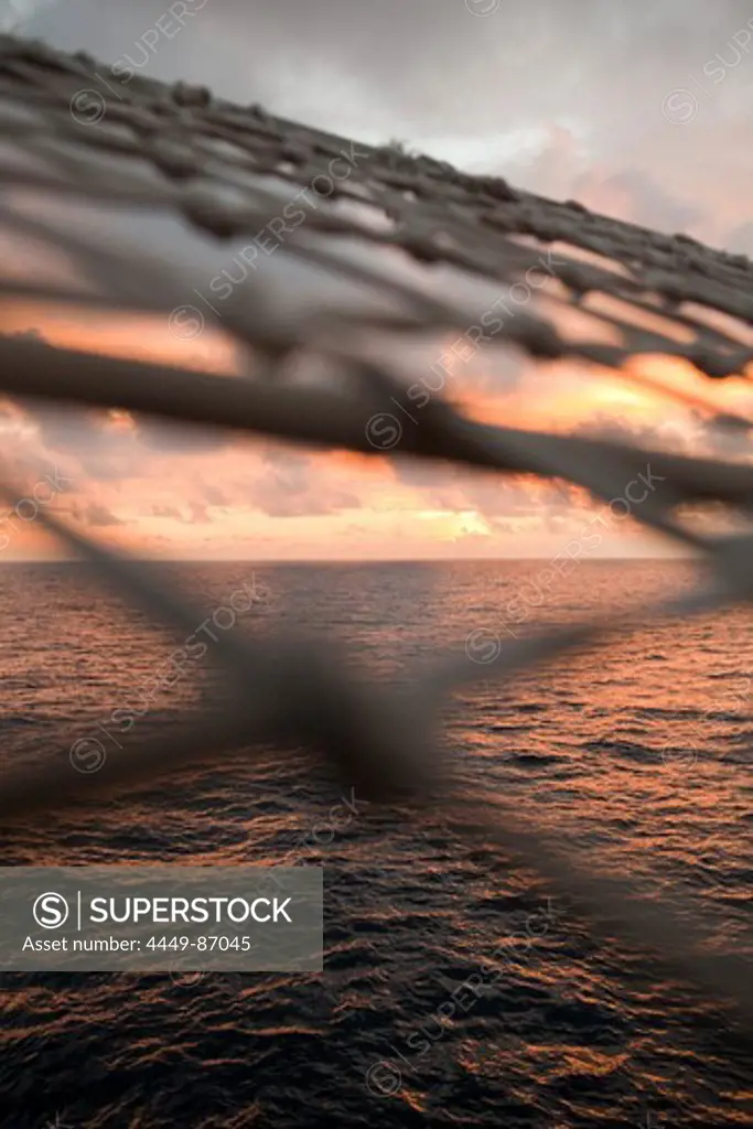 Sunset view through bowsprit net of sailing cruiseship Star Flyer (Star Clippers Cruises), Pacific Ocean, near Costa Rica, Central America, America