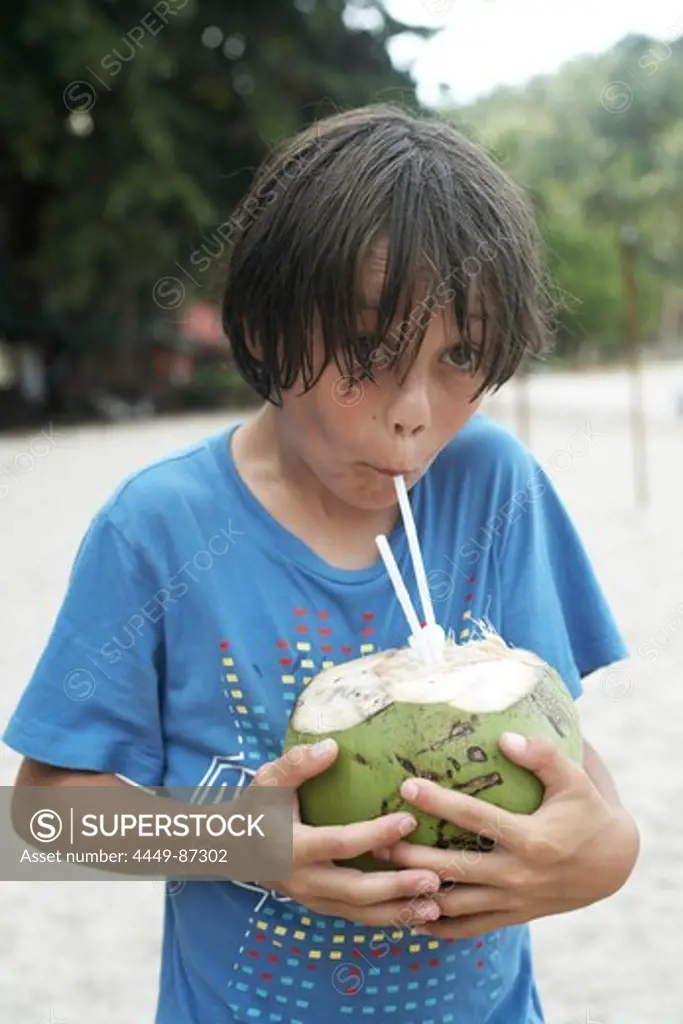 Boy (8 years) drinking fresh coconut milk, Haad Thong Reng, Island of Ko Pha Ngan, Surat Thani, Thailand