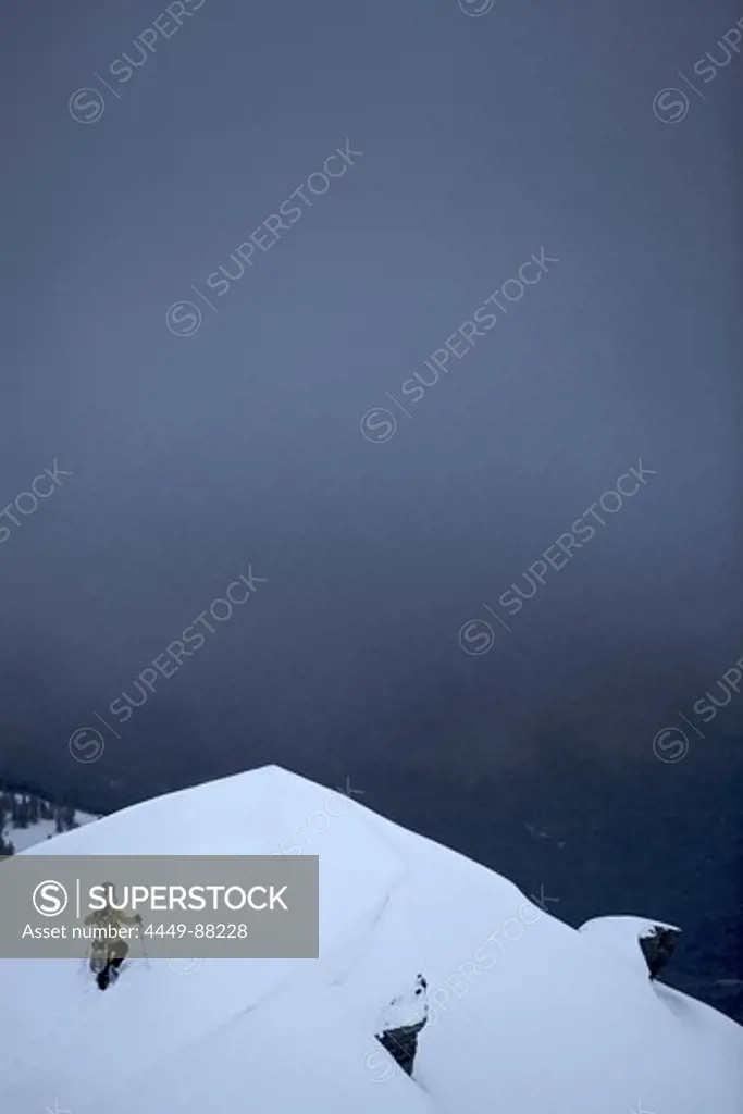 Snowboarder ascending through deep snow, Chandolin, Anniviers, Valais, Switzerland