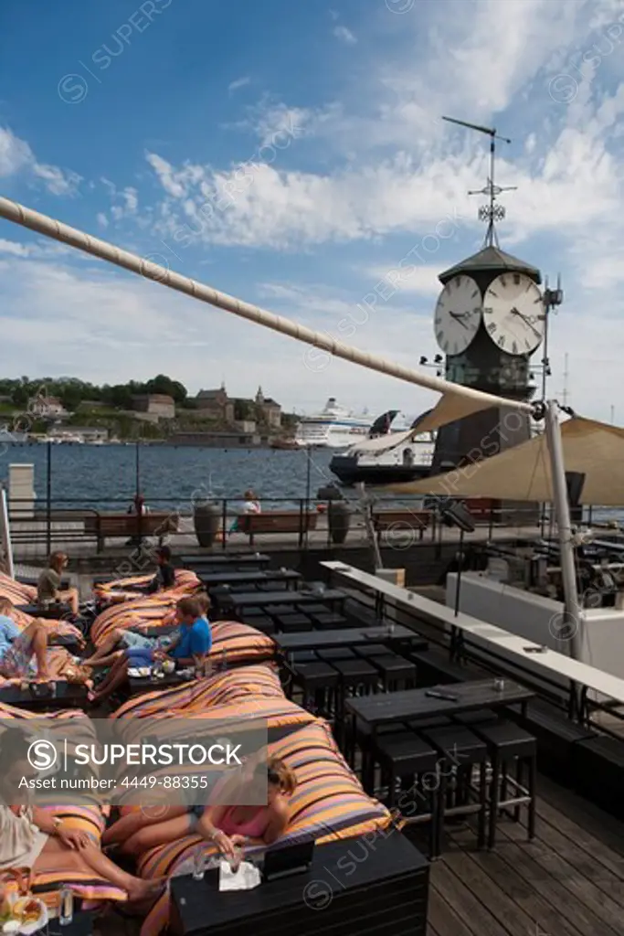Young women relaxing on lounger chairs in the harbour, Oslo, Oslo, Norway