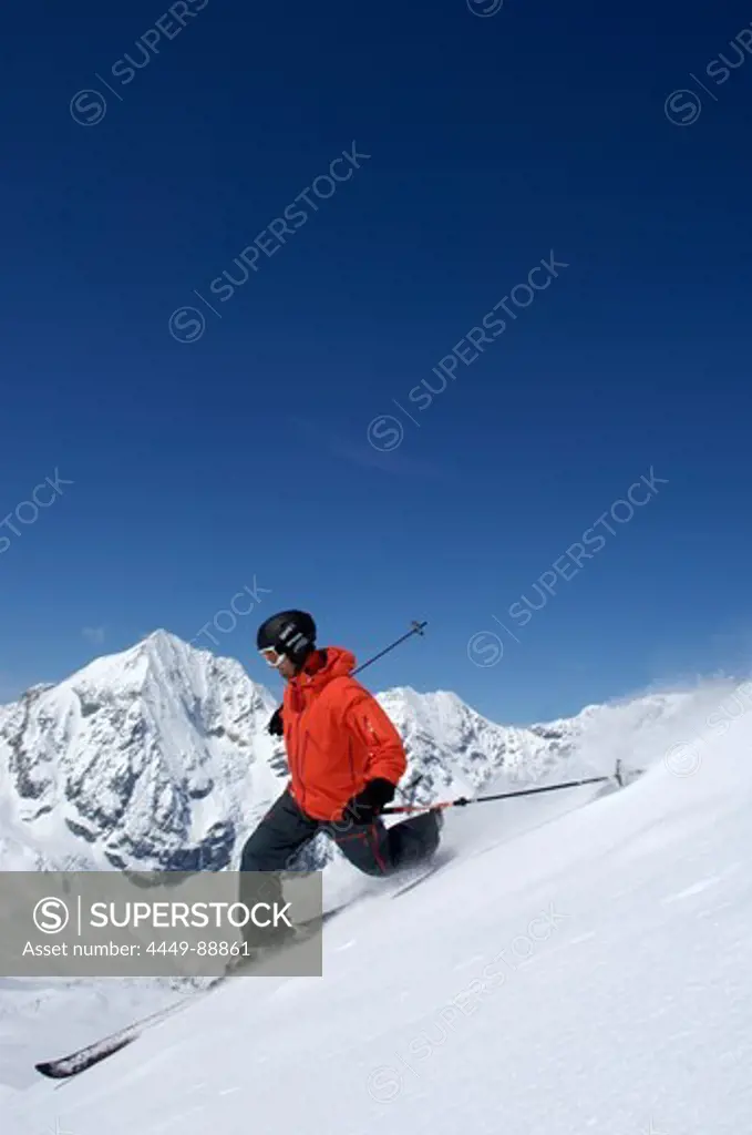 Skier skiing with full winter equipment, Koenigspitze, Ortler Alps, South Tyrol, Trentino-Alto Adige, Italy