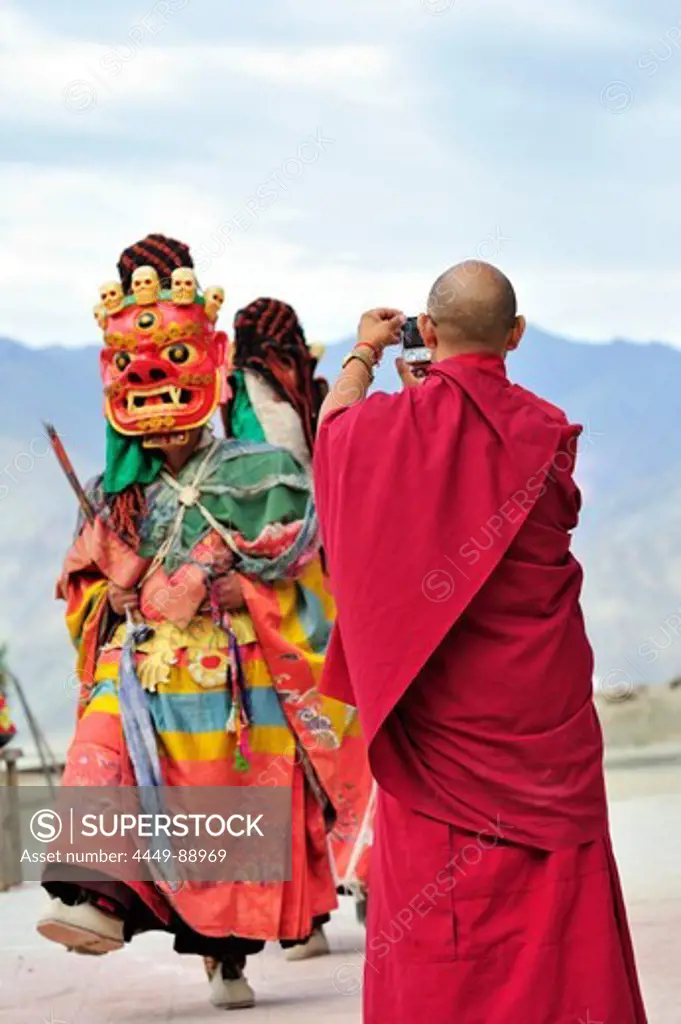 Monk taking pictures at mask dance at monastery festival, Phyang, Leh, valley of Indus, Ladakh, Jammu and Kashmir, India
