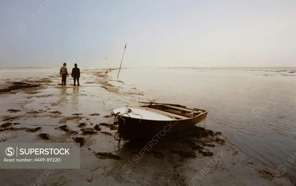 Two men with a rowboat in a tidal creek, East Frisian Wadden Sea, East Friesland, North Sea, Lower Saxony, Germany, Europe