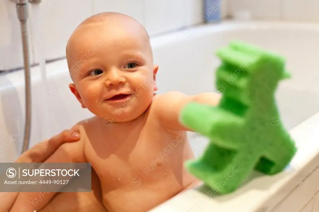Little boy in the bathtub, playing with Ampelmaennchen, symbol of the former GDR, symbol of East German traffic light, green man, baby, 10 months old, MR, Leipzig, Sachsen, Germany