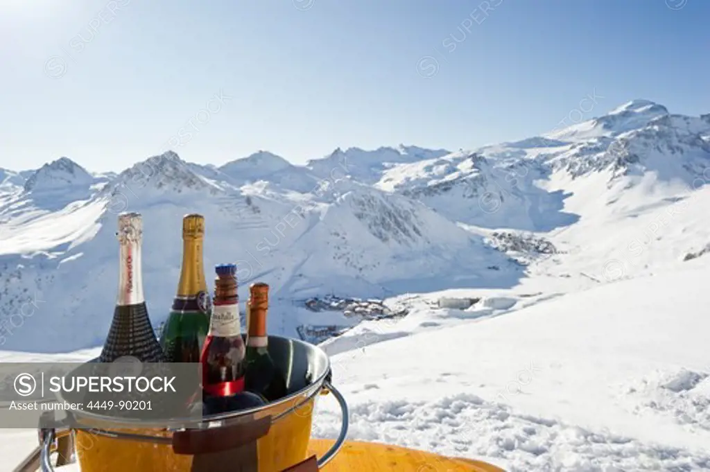 Bottles of champagne in a cooler, Snow-capped mountains in the background, Tignes, Val d Isere, Savoie department, Rhone-Alpes, France