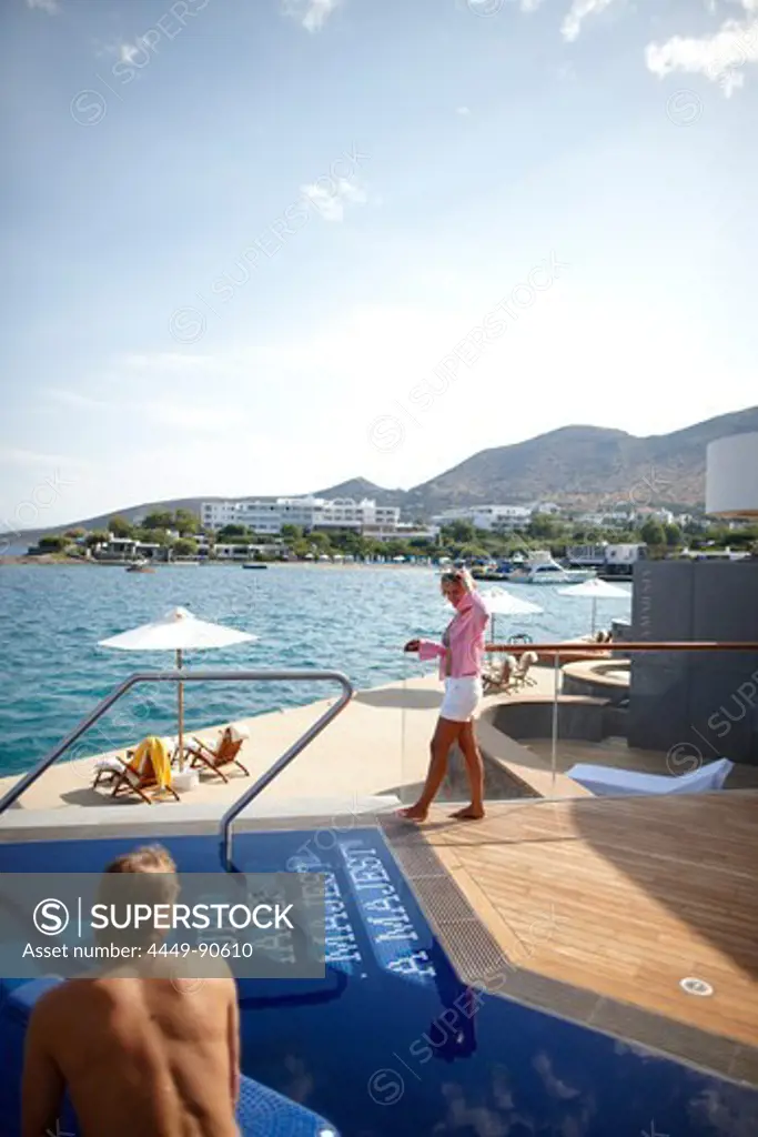 Man and woman at the pool and deck of the Yachting Club Villas, Elounda Beach Resort, Elounda, Crete, Greece