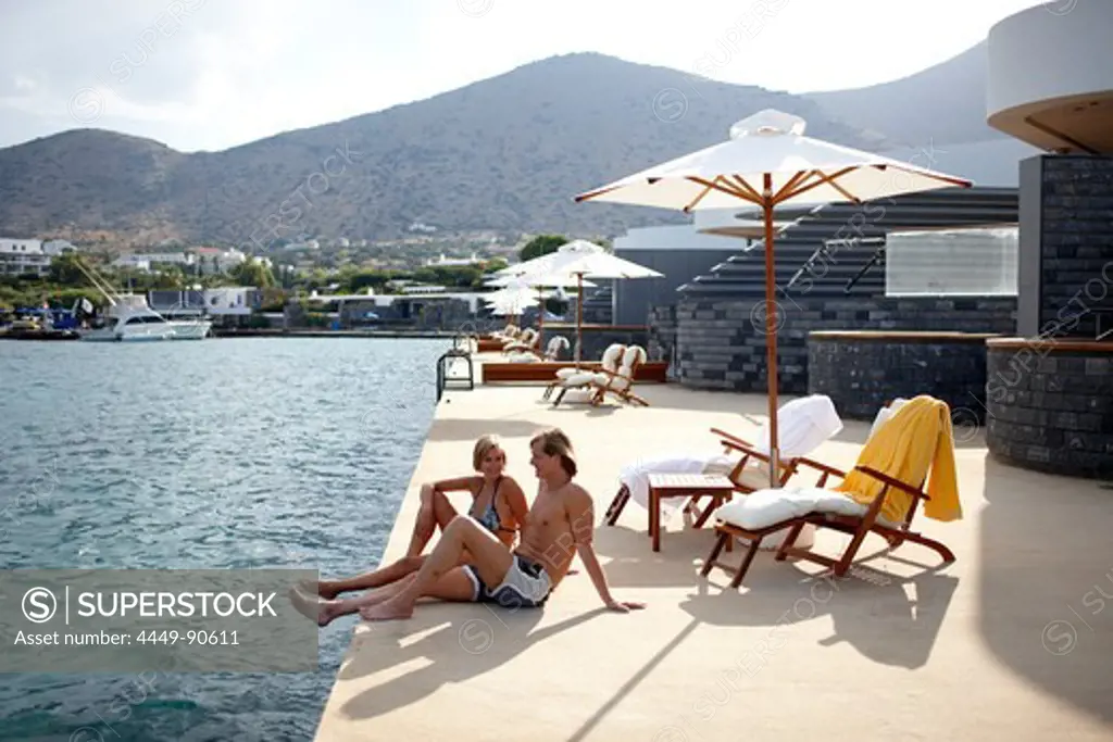 Couple sunbathing on the terrace of Yachting Club Villas, Elounda Beach Resort, Elounda, Crete, Greece