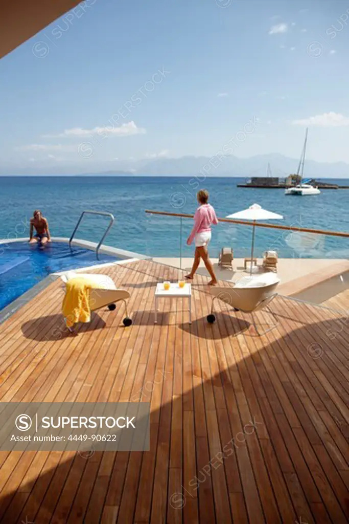 Man and woman at the pool and deck of Yachting Club Villas, Elounda Beach Resort, Elounda, Crete, Greece