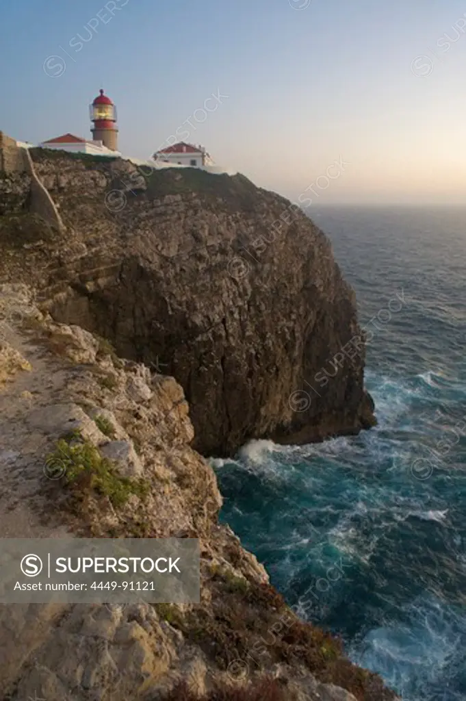 Lighthouse on high cliffs above ocean in evening mood, Cabo de Sao Vicente, Algarve, Portugal, Europe