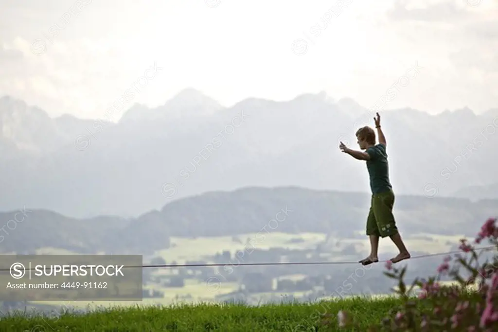 Young man balancing on a longline, Auerberg, Bavaria, Germany, Europe