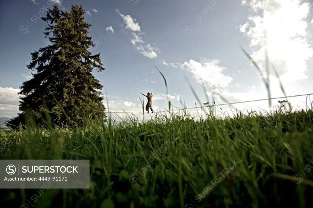 Young man balancing on a longline, Auerberg, Bavaria, Germany, Europe