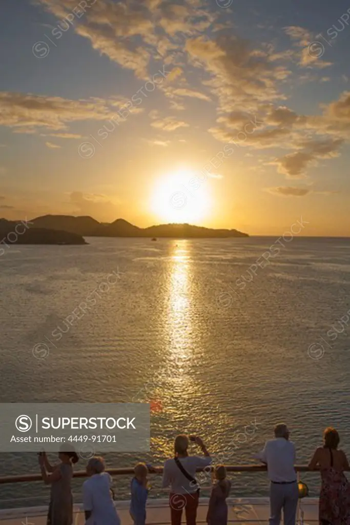 People standing at the railing of cruise ship MS Deutschland (Reederei Peter Deilmann) and admiring the sunset, near St. John's, St. John, Antigua, Antigua and Barbuda, Caribbean