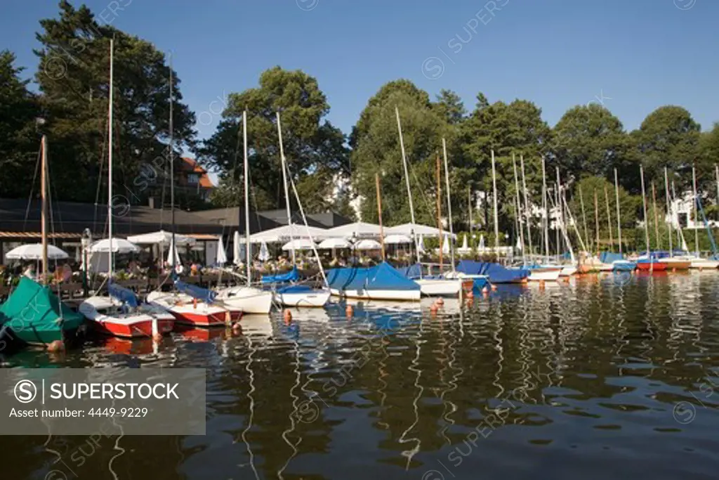 Sailingboats in front of restaurant at lake Alster, Hamburg, Germany