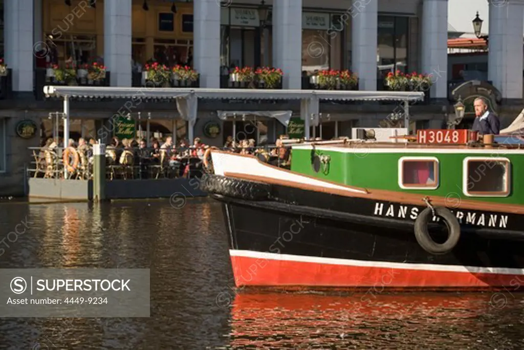 Excursion with a barge, Barge on a loading canal during a excursion passing a cafe at Alsterarkaden, Hamburg, Germany