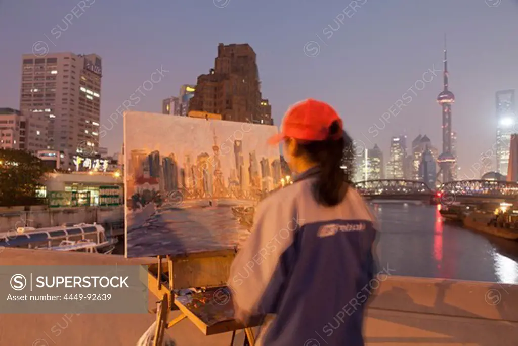 Artist painting the Huangpu river with Waibaidu bridge and skyline of Pudong, Shanghai, China, Asia