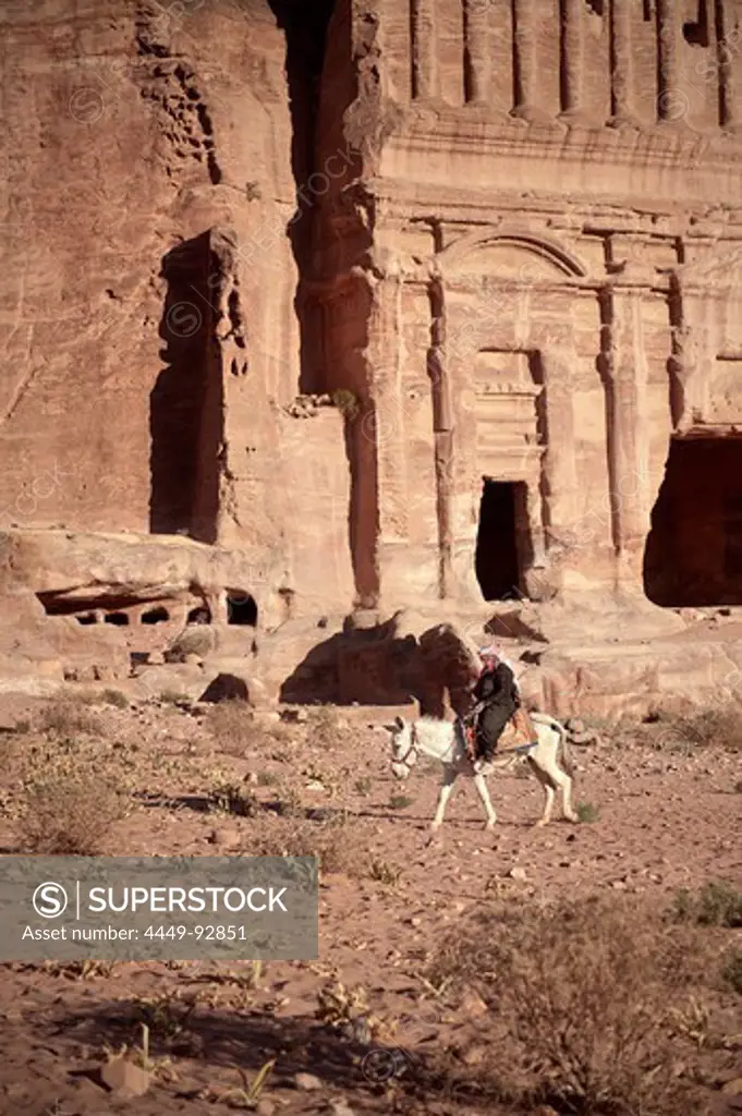 Beduin woman riding donkey in front of Royal Tomb, Petra, UNESCO world herritage, Wadi Musa, Jordan, Middle East, Asia