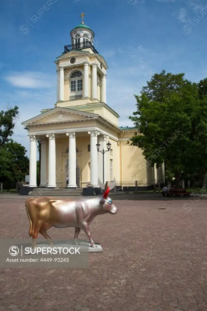 Cow sculpture Cow of Golden Sun and Silver Moon by artist Helena Heinrihsone is part of the Ventspils CowParade art project and situated on the town hall square by St. Nicholas Lutheran church, Ventspils, Latvia, Baltic States, Europe