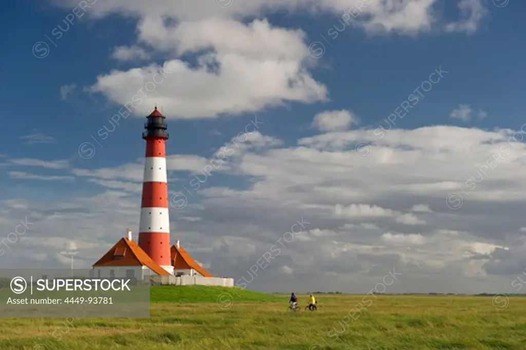 Westerheversand lighthouse and cyclists, Westerhever, Wadden Sea National Park, Eiderstedt peninsula, North Frisian Islands, Schleswig-Holstein, Germany, Europe