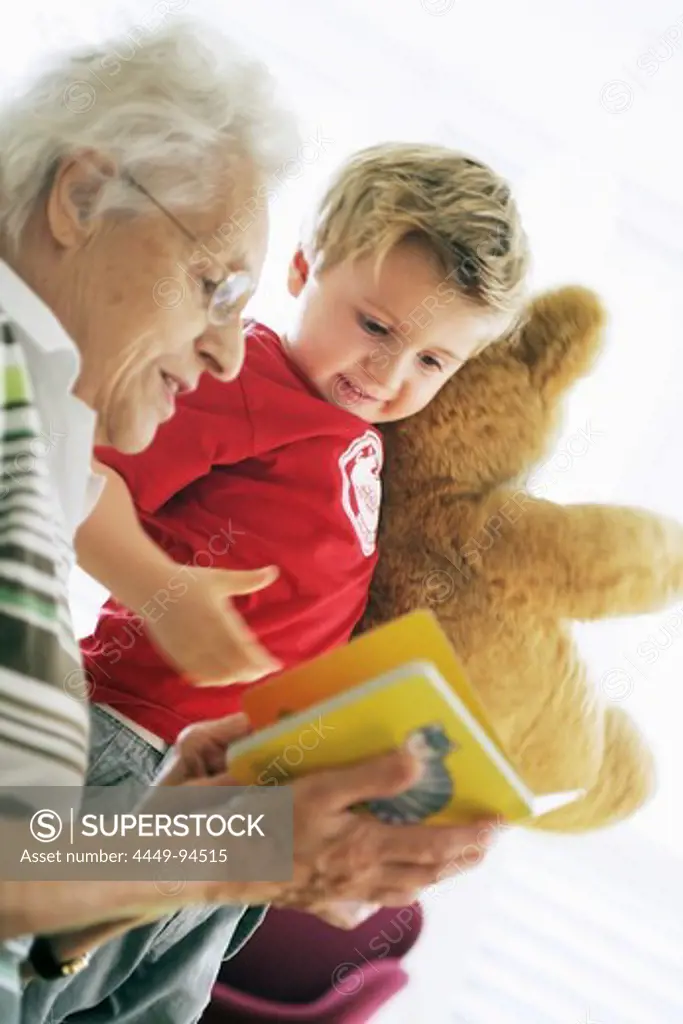 Grandmother and grandchild reading a book together