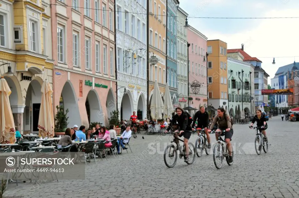 Four cyclists cycling over Max-Joseph-Place, Rosenheim, Bavaria, Germany