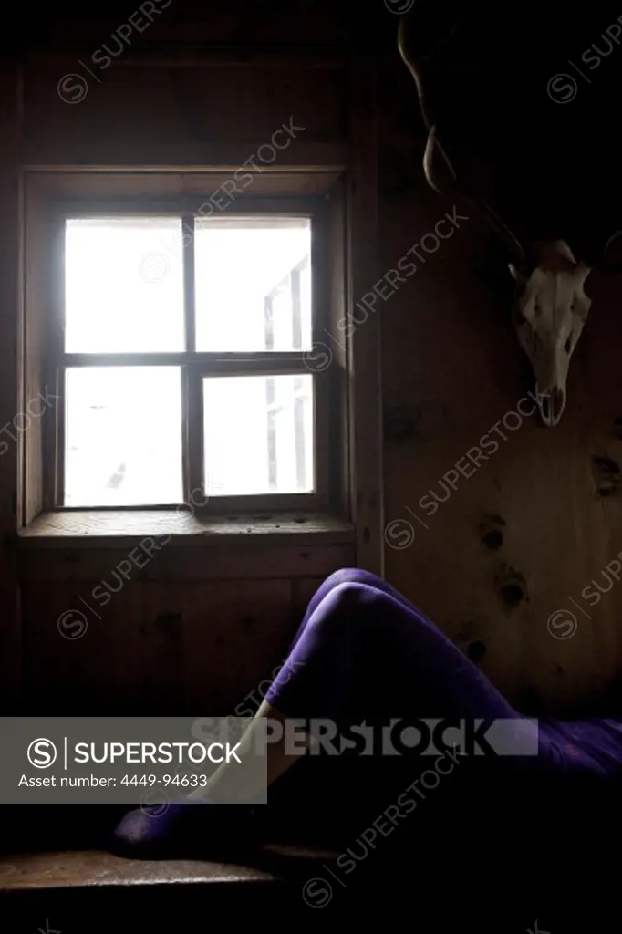 Young woman relaxing after skiing in a cosy alpine hut, See, Tyrol, Austria