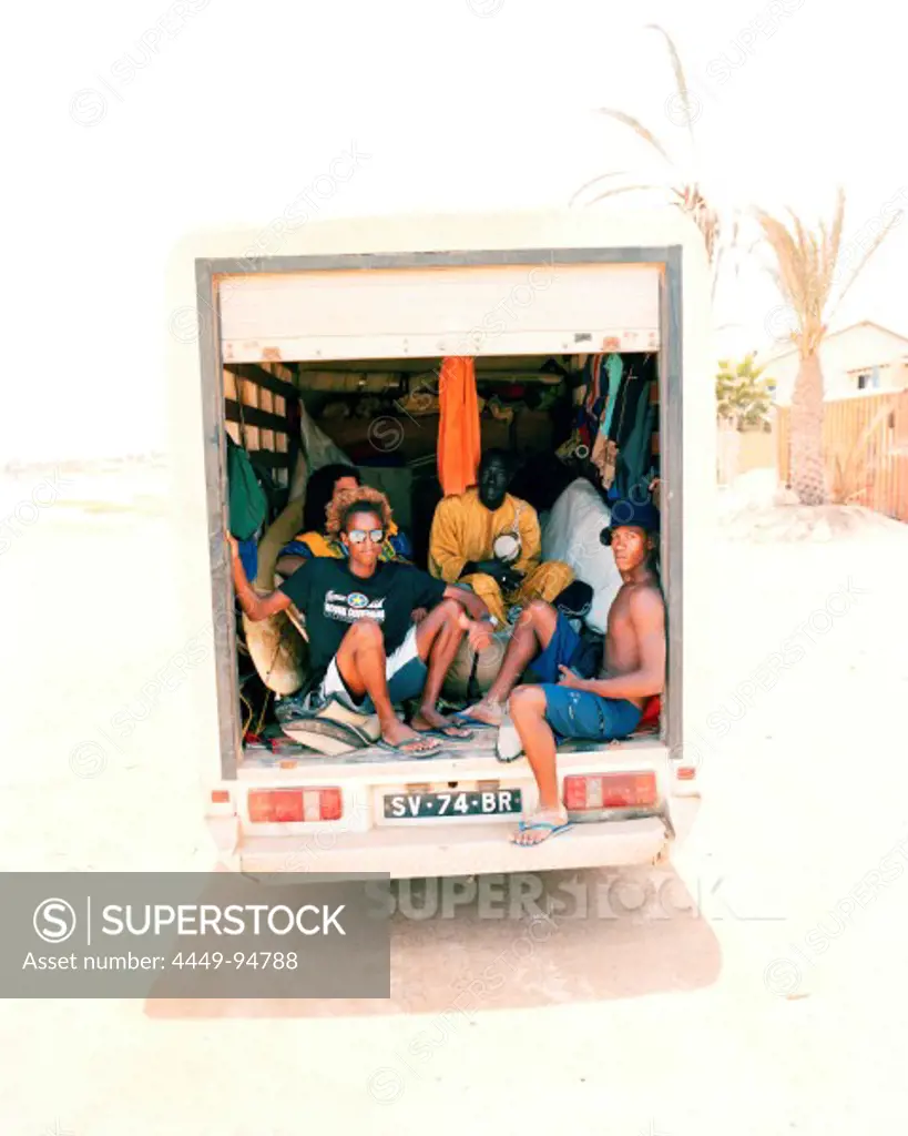 Delivery truck with surfers and african musicians driving to surf spot Ponta Preta, west of Santa Maria, Sal, Ilhas de Barlavento, Republic of Cape Verde, Africa