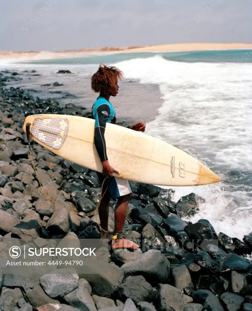 Cape Verdean goes surfing at Ponta Preta, west of Santa Maria, Sal, Ilhas de Barlavento, Republic of Cape Verde, Africa