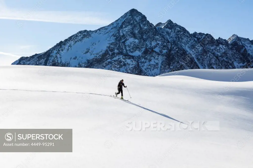 Backcountry skier at Hohe Gruben, ascending Schoentalspitz, overlooking Lisenser Fernerkogl, Rotgratspitz and Lisenserspitz, Sellrain, Innsbruck, Tyrol, Austria