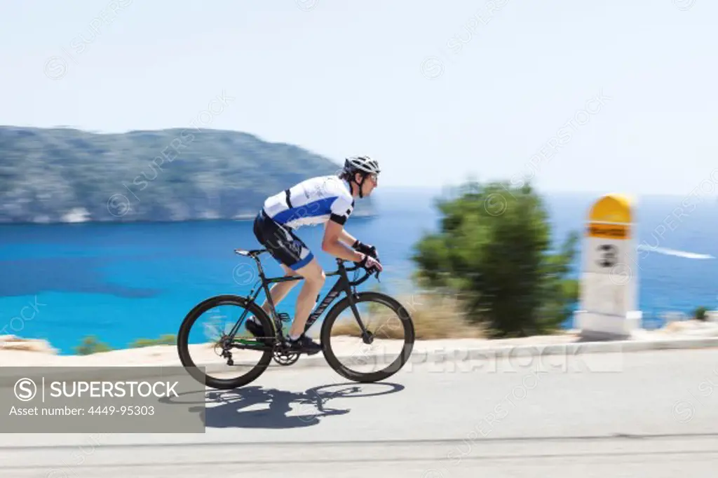 Bicycle rider at the Mediterranean coast, Andratx, Majorca, Balearic Islands, Spain