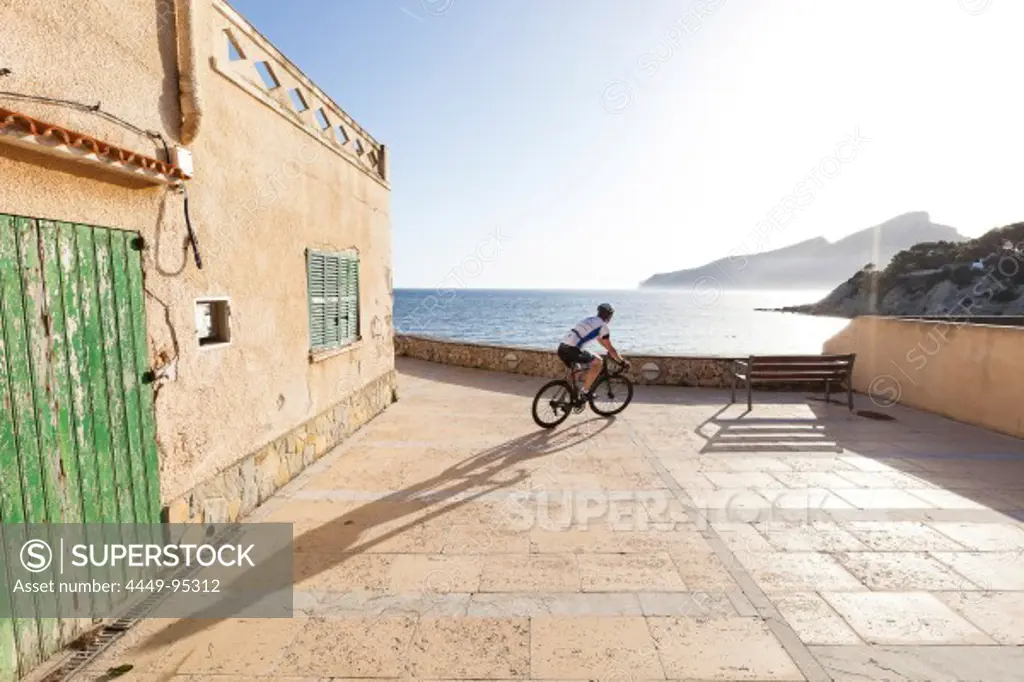 Bicycle rider at the Mediterranean coast, Sant Elm, Majorca, Balearic Islands, Spain