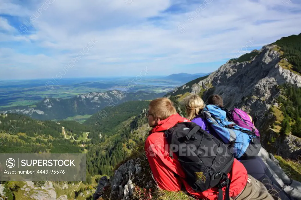 Young woman and two young men enjoying the view from Aggenstein to Fuessen, Aggenstein, Tannheim range, Tyrol, Austria