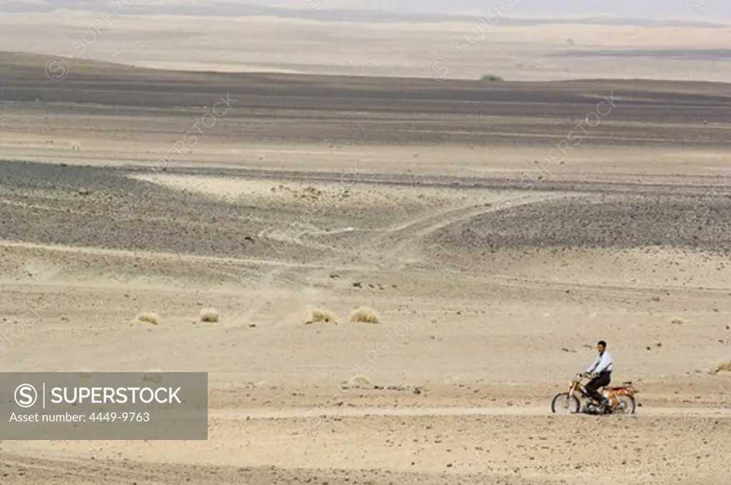 Motorcyclist in the desert, Erg Chebbi, Morocco