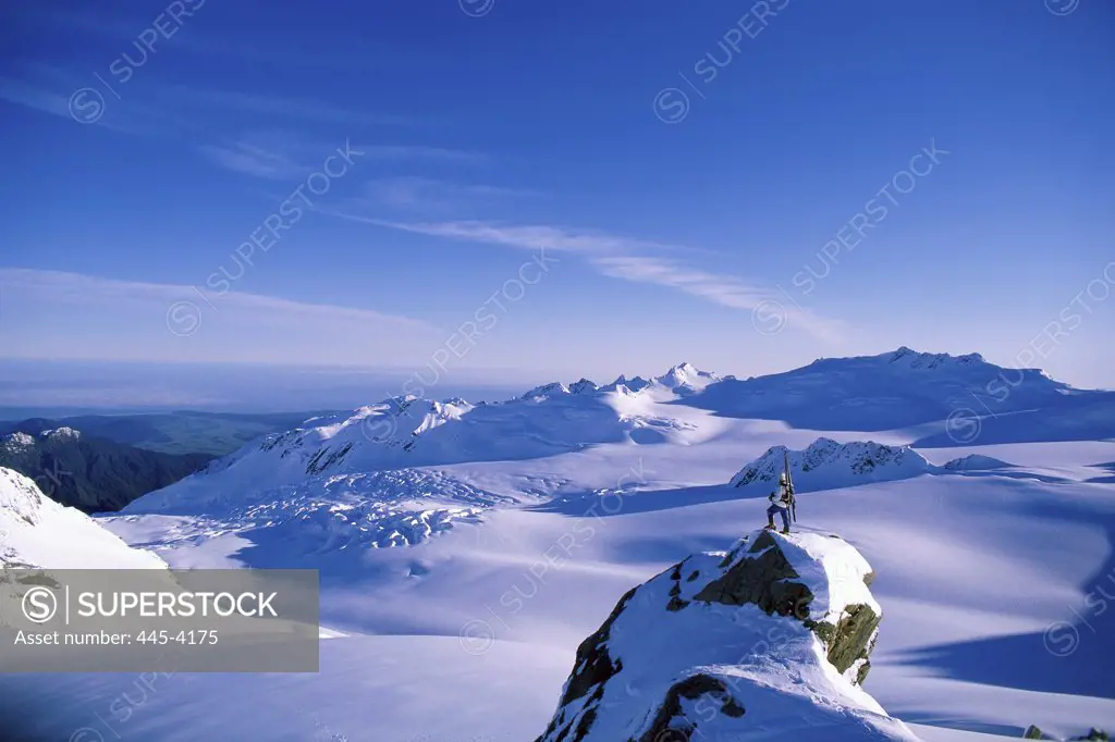 Man standing on top of a snow covered peak, Mount Cook National Park, New Zealand