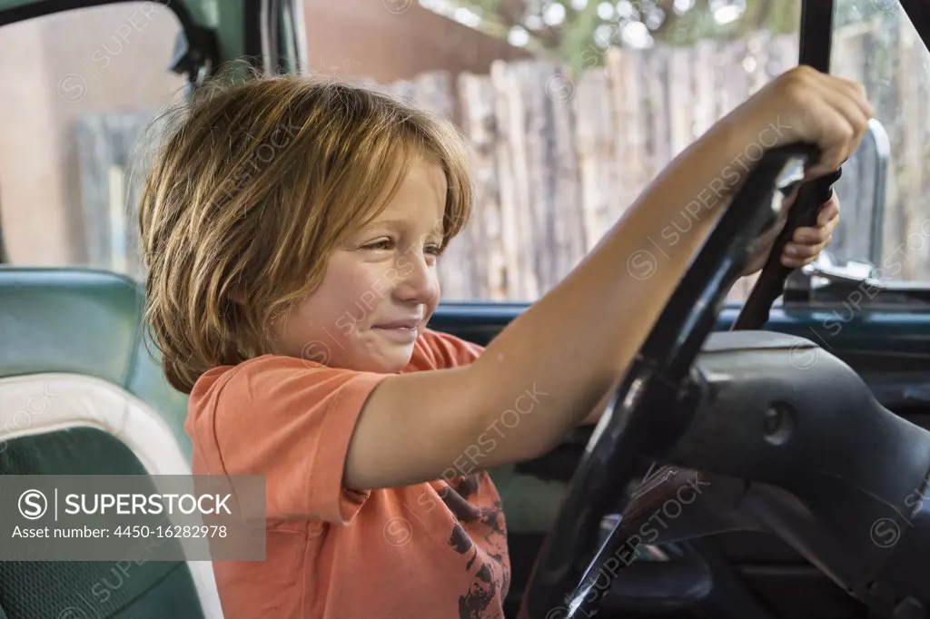 5 year old boy behind the wheel of 1970's pick up truckNM.